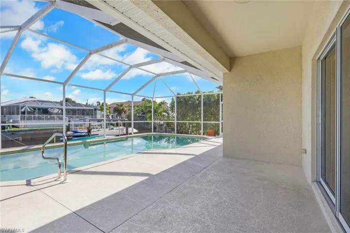 Swimming pool with a patio area, a lanai, and a sunroom