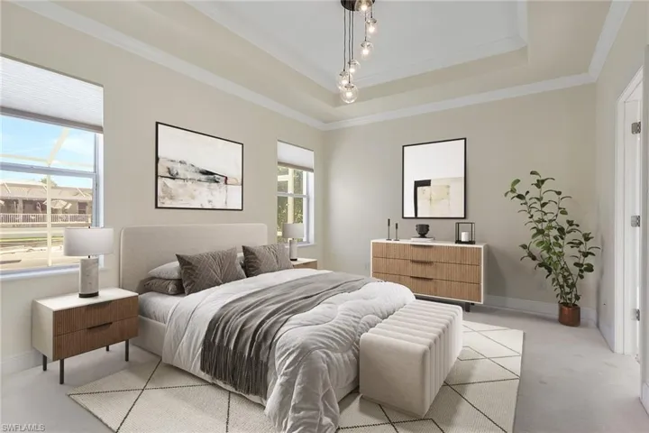 Carpeted bedroom with crown molding and a tray ceiling