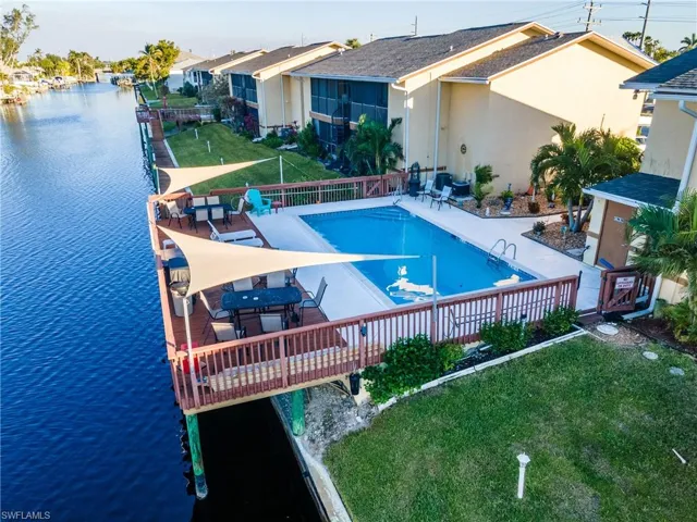 View of swimming pool with a yard, a water view, and a patio