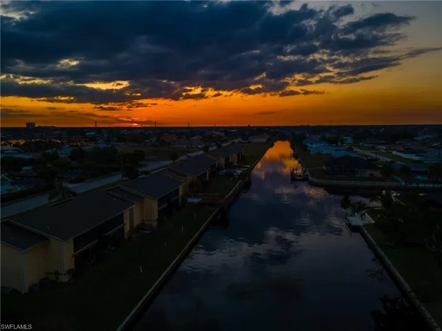 Aerial view at dusk featuring a water view