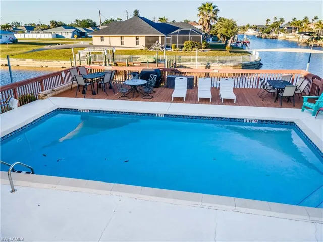 View of pool with a deck with water view
