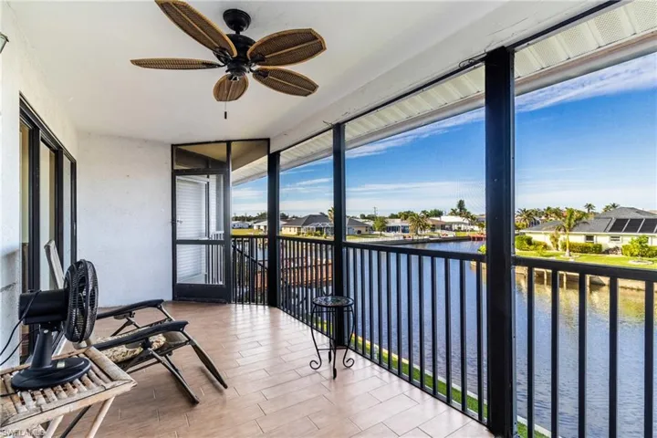 Sunroom featuring ceiling fan and a water view