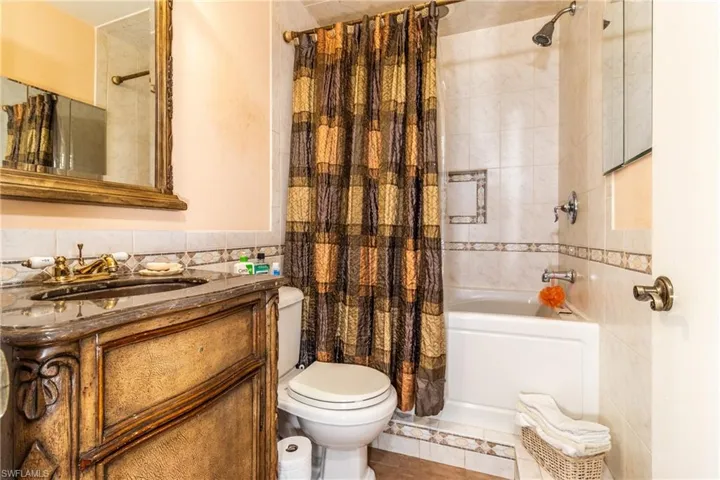 Full bathroom featuring tile patterned floors, vanity, shower / bath combo, and toilet