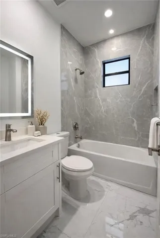 Full bath with shower / tub combination, vanity, light marble finish flooring, and recessed lighting