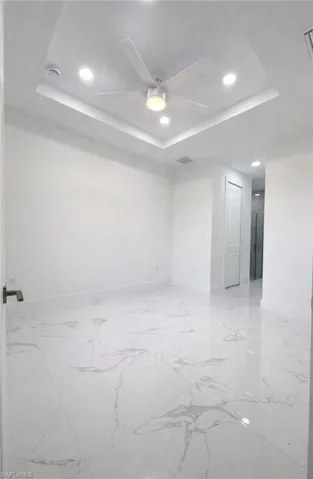 Unfurnished room with a tray ceiling, recessed lighting, and ceiling fan