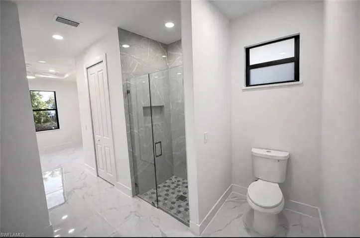 Full bath with a marble finish shower, marble finish floors, recessed lighting, and a closet