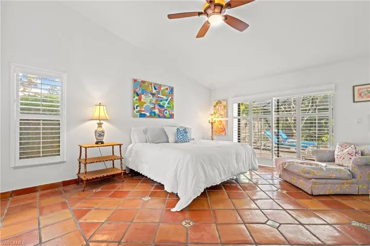 Tiled bedroom with lofted ceiling, access to outside, and a ceiling fan