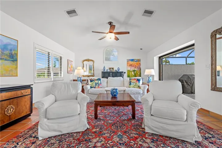 Tiled living area featuring lofted ceiling and ceiling fan