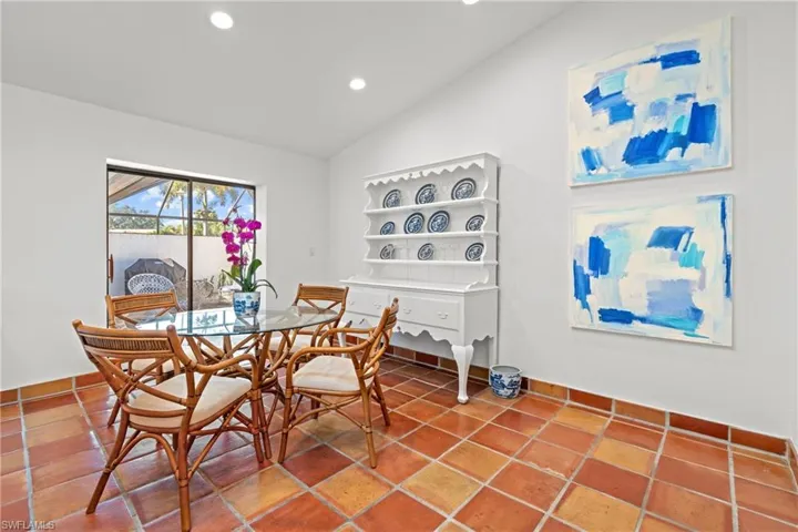 Tiled dining room featuring vaulted ceiling, recessed lighting, and a sunroom