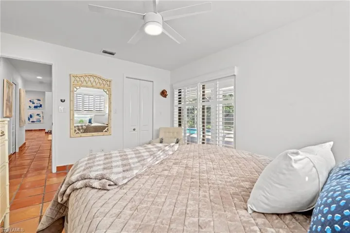 Tiled bedroom with multiple windows, access to exterior, a closet, and ceiling fan