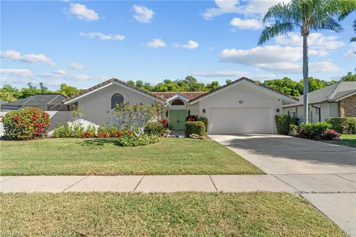 Ranch-style home with stucco siding, a front lawn, concrete driveway, and an attached garage