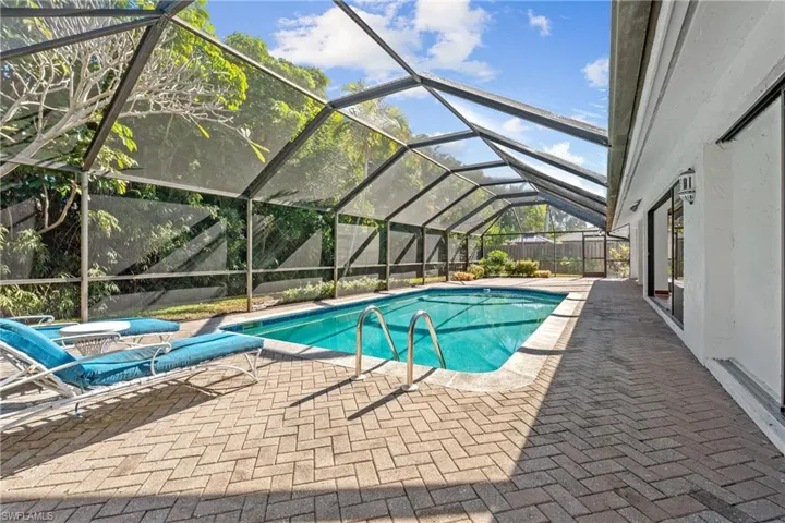 Swimming pool featuring a patio area, a lanai, and a sunroom