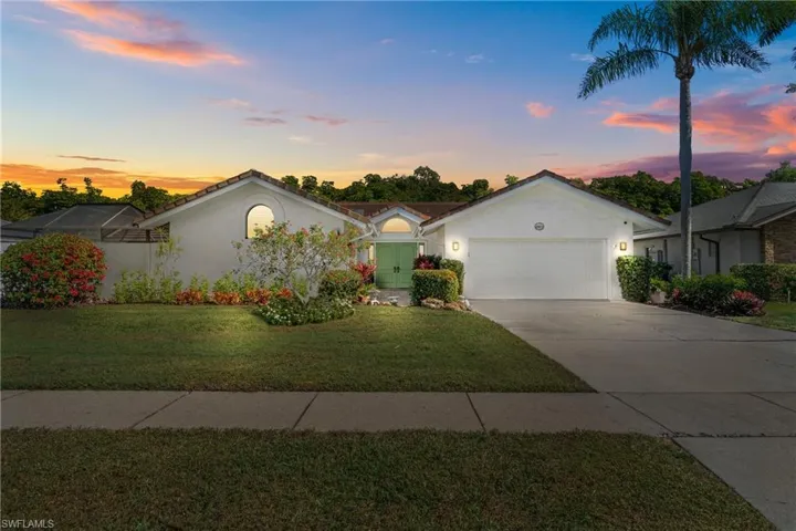 Ranch-style home featuring stucco siding, concrete driveway, a lawn, and an attached garage