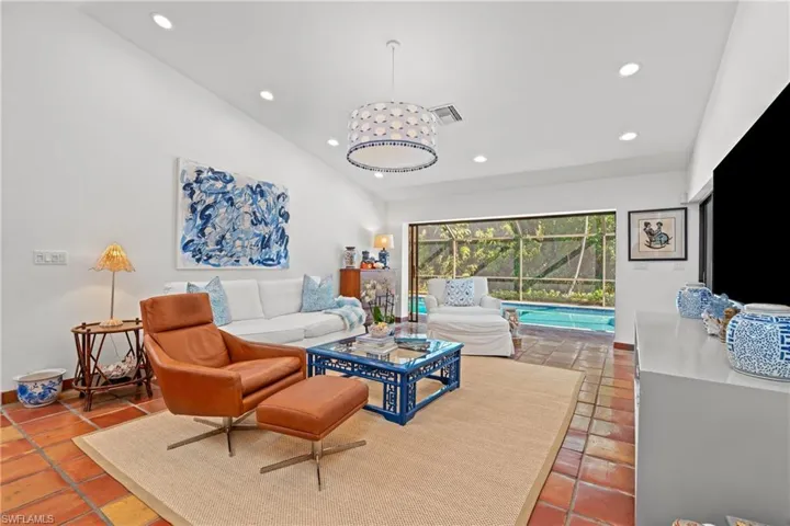 Living room featuring lofted ceiling, recessed lighting, and a sunroom