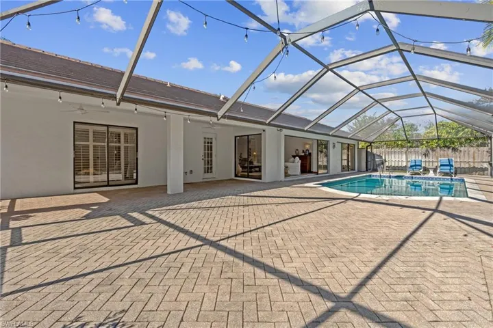 View of swimming pool with a lanai, a sunroom, and a patio