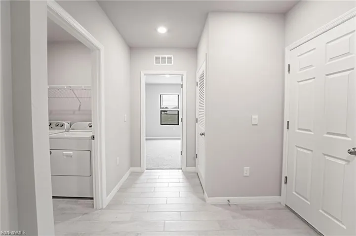 Hallway featuring baseboards and independent washer and dryer
