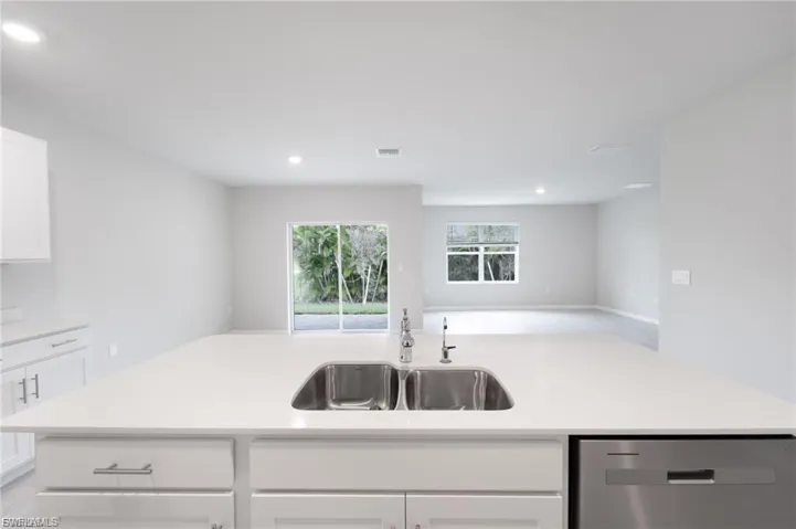 Kitchen with white cabinets, dishwasher, recessed lighting, an island with sink, and open floor plan