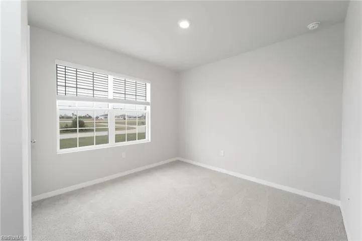 Carpeted empty room featuring baseboards and recessed lighting