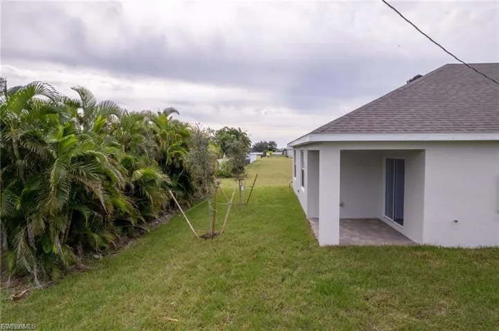 View of grassy yard featuring a patio area