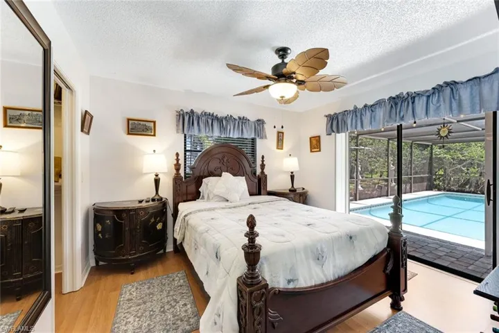 Bedroom with access to exterior, a textured ceiling, light wood-type flooring, and ceiling fan