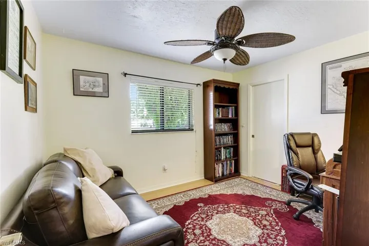 Home office featuring wood finished floors, ceiling fan, and a textured ceiling