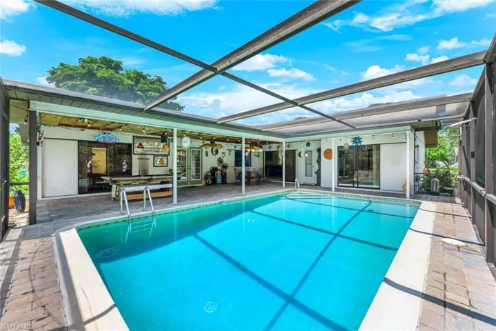 Swimming pool featuring a patio and glass enclosure