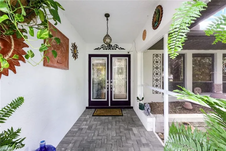 Doorway to property featuring stucco siding and french doors
