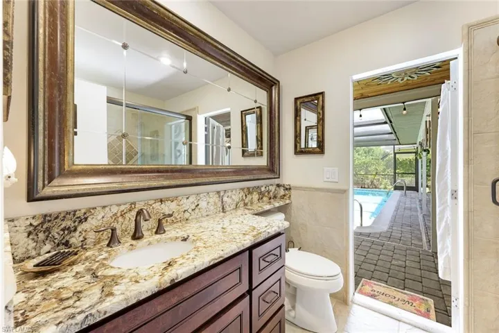 Bathroom featuring vanity, a stall shower, tile walls, and tile patterned floors