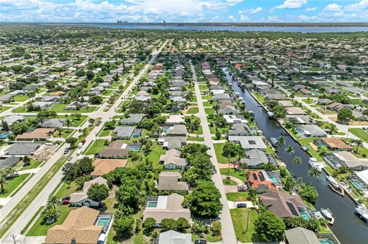 Aerial perspective of suburban area featuring a nearby body of water