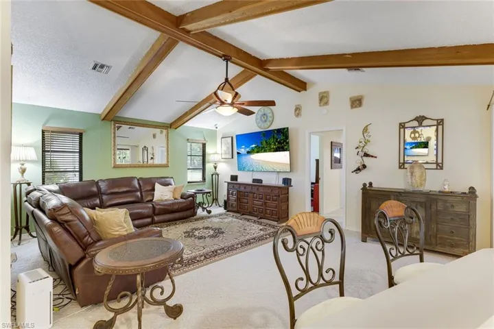 Living room featuring carpet flooring, ceiling fan, and a textured ceiling