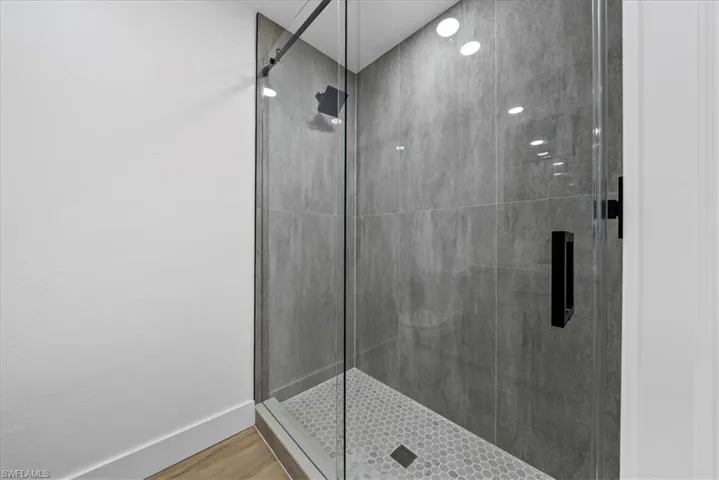 Full bathroom with a stall shower and wood finished floors