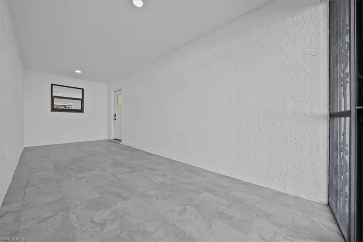 Spare room featuring a textured wall and recessed lighting