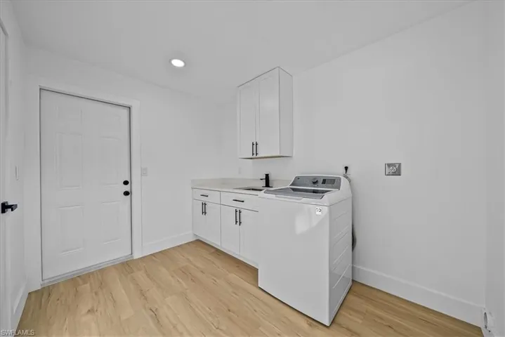 Laundry room with washer / clothes dryer, light wood finished floors, cabinet space, and recessed lighting