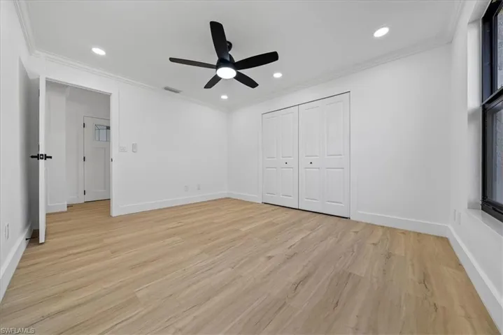 Unfurnished bedroom featuring ornamental molding, light wood finished floors, recessed lighting, a ceiling fan, and a closet