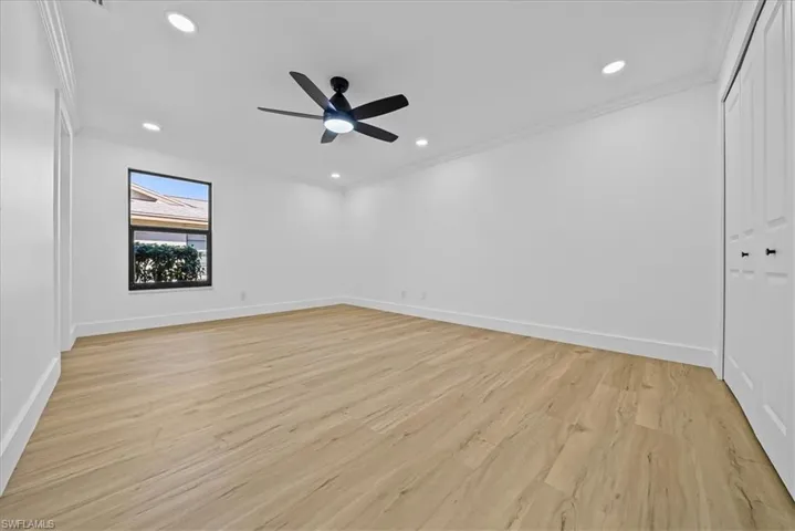 Unfurnished bedroom featuring recessed lighting, crown molding, light wood-style floors, ceiling fan, and a closet
