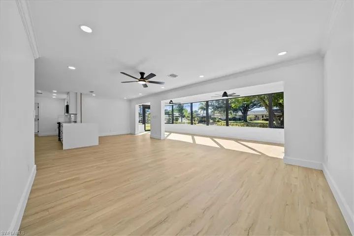Unfurnished living room with light wood-style floors, ornamental molding, recessed lighting, and a ceiling fan