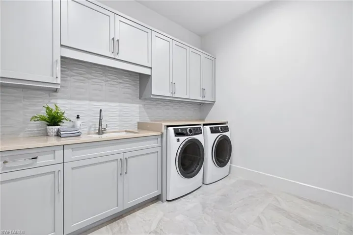 Large laundry room, with full size washer and dryer ,sink with plenty of cabinets for storage