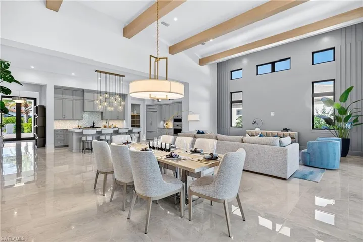 Seamlessly connected to the living space, the spacious dining area comfortably accommodates large gatherings and is anchored by a contemporary chandelier