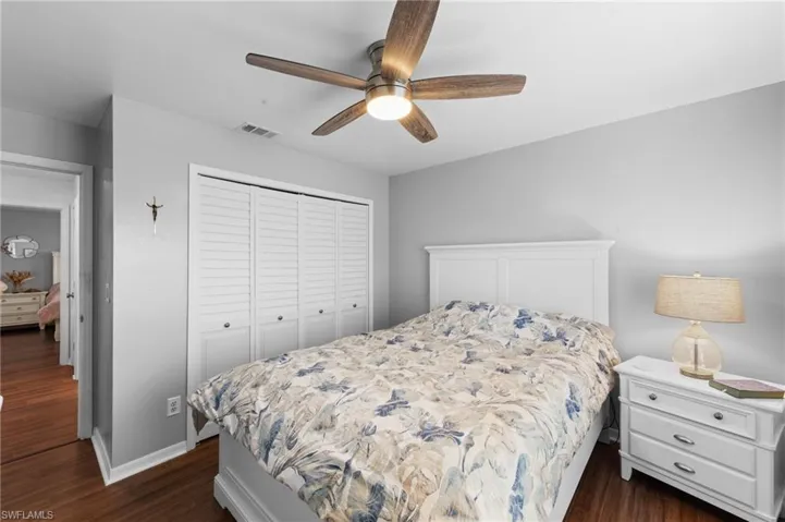 Bedroom with dark wood-type flooring, a closet, and ceiling fan
