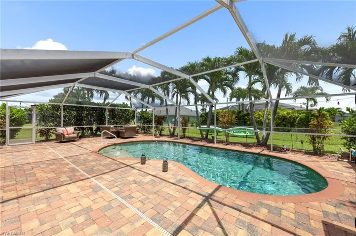 Outdoor pool with a patio and glass enclosure