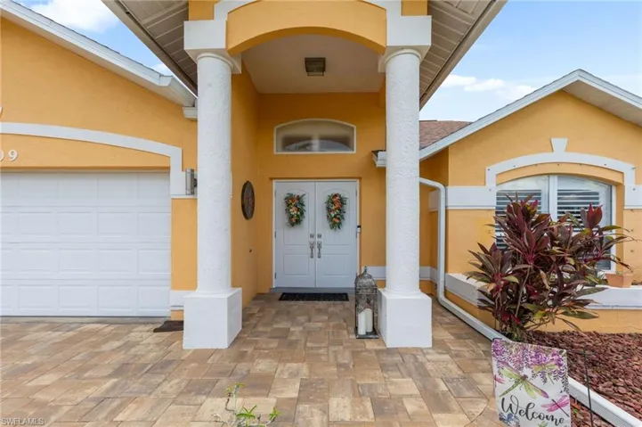 View of exterior entry featuring stucco siding and an attached garage