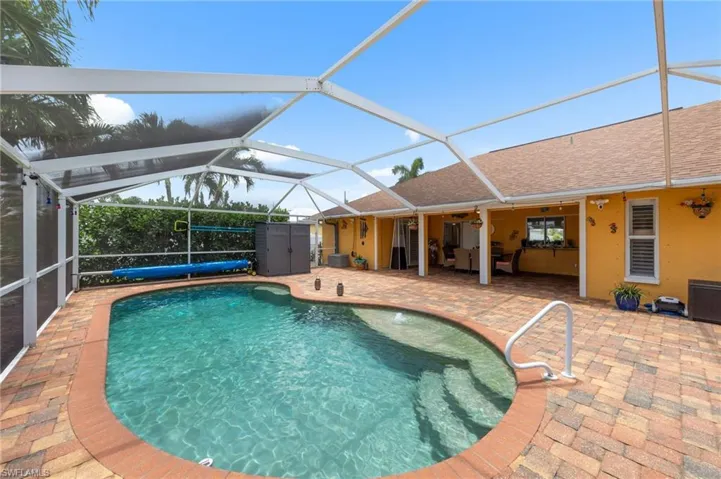 Swimming pool featuring a patio area, glass enclosure, and ceiling fan