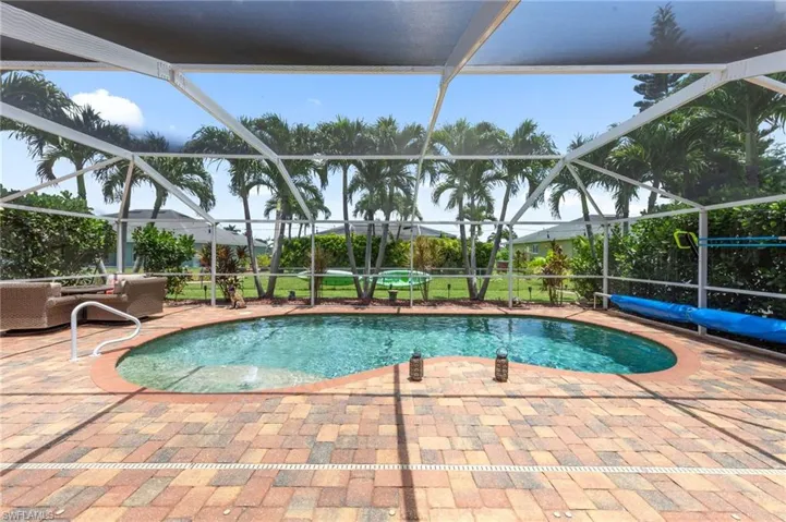 Swimming pool with a patio area and glass enclosure