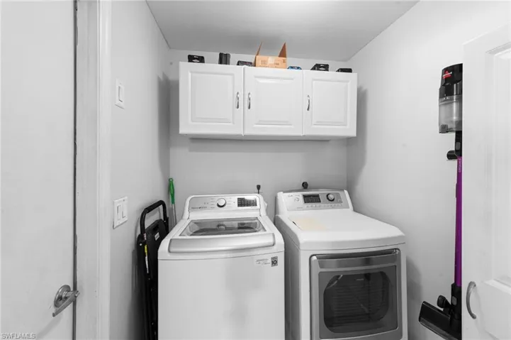 Washroom with cabinet space and washer and clothes dryer