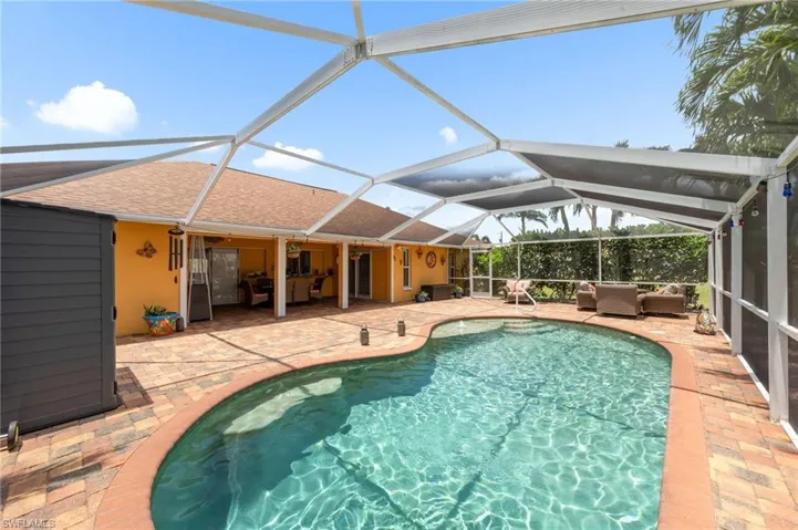 Swimming pool featuring a patio area, an outdoor living space, and glass enclosure