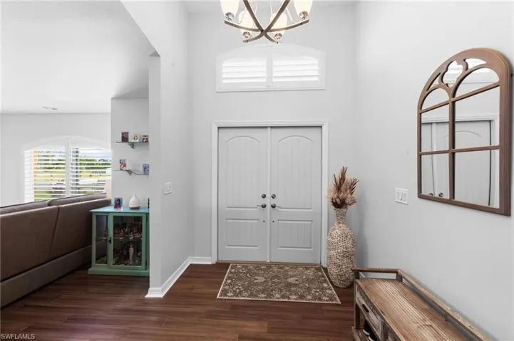 Entrance foyer featuring plenty of natural light, a chandelier, dark wood-type flooring, and a high ceiling