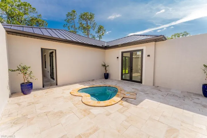 View of swimming pool with a patio area, french doors, and an in-ground hot tub