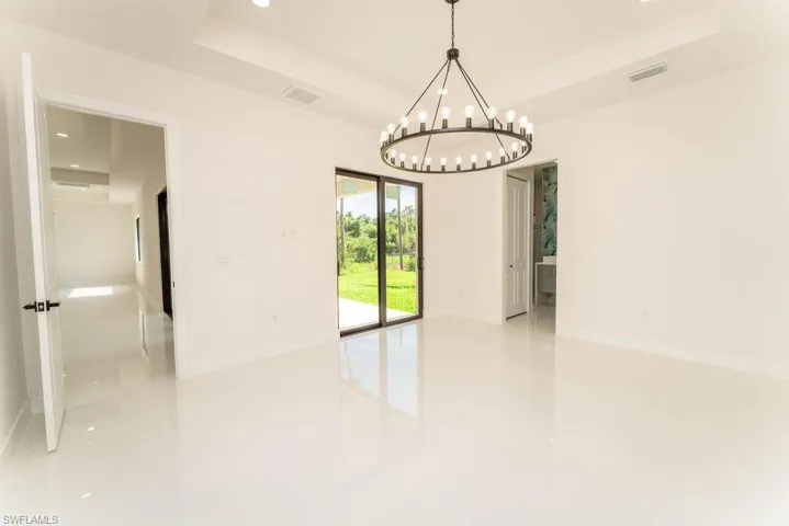 Unfurnished room with a tray ceiling, recessed lighting, and a chandelier
