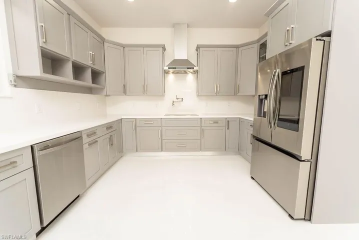 Kitchen with appliances with stainless steel finishes, gray cabinetry, wall chimney range hood, open shelves, and recessed lighting