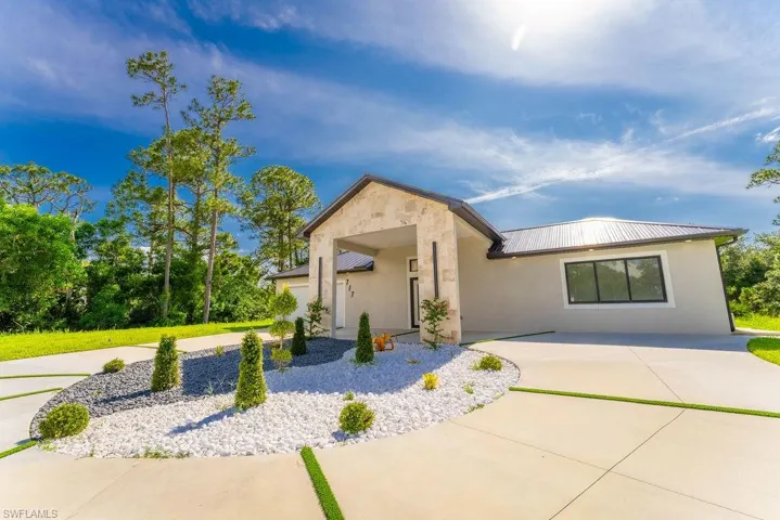 View of front of property featuring a metal roof and stucco siding